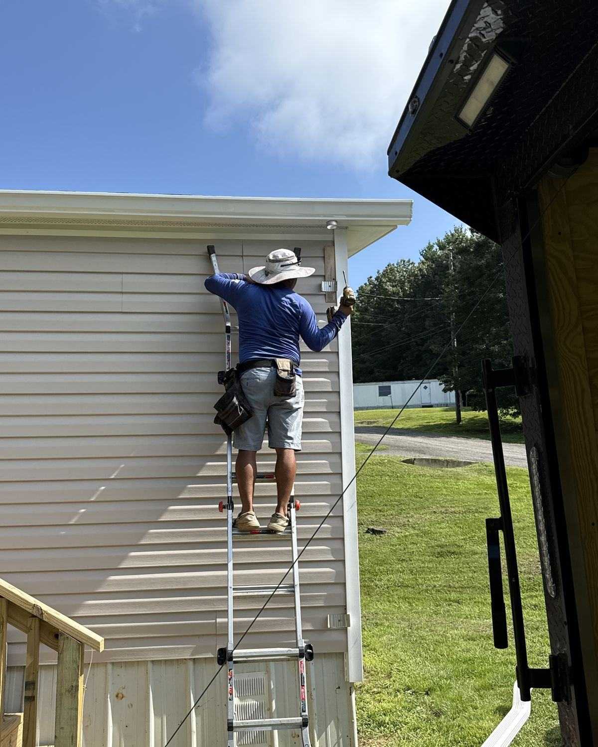 Crew member on a ladder installing a gutter section